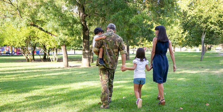 soldier-walking-through-field-with-his-family