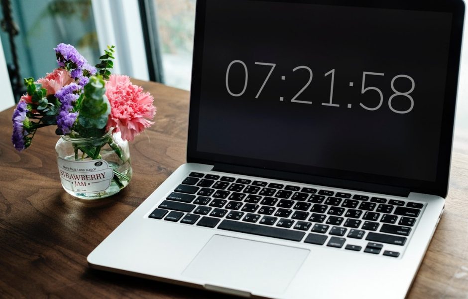 laptop computer displaying the time with flowers