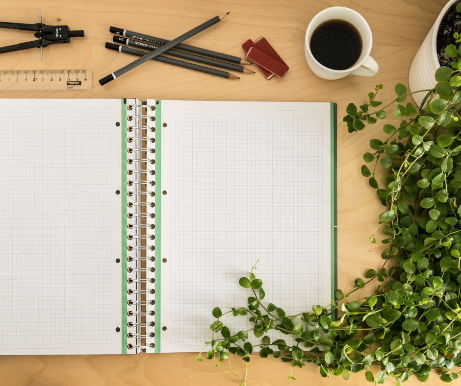 empty notebook surrounded by pencils and plant