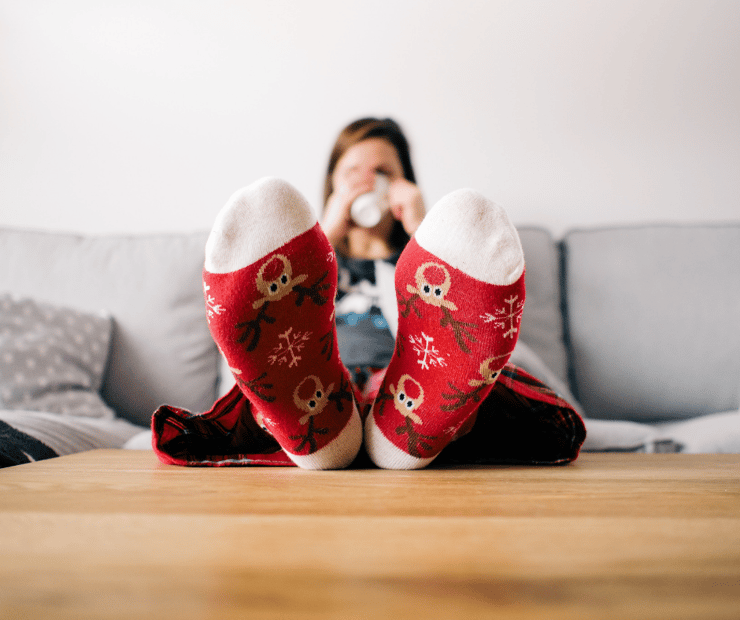 woman wearing Christmas socks while sitting on couch