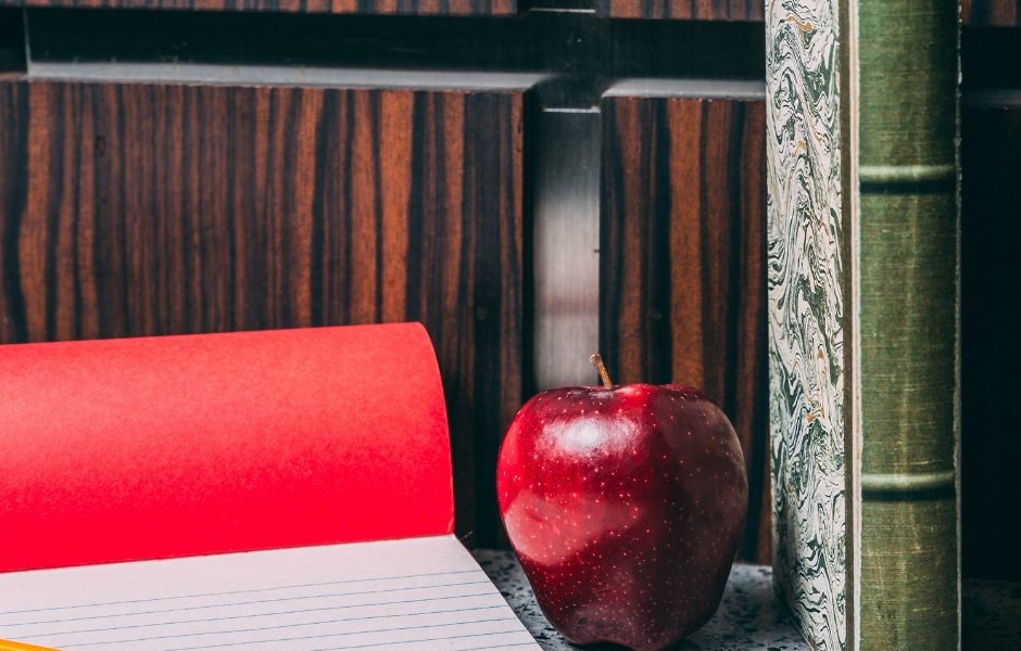 notepad, apple and book on a desk