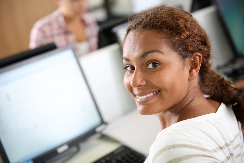 Smiling woman sitting in front of desktop