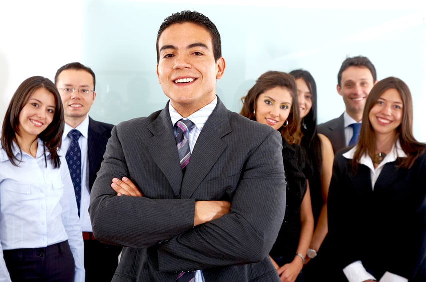 business man smiling leading a team in an office