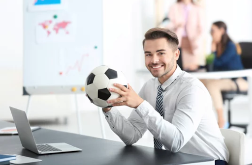 executive holding soccer ball at desk